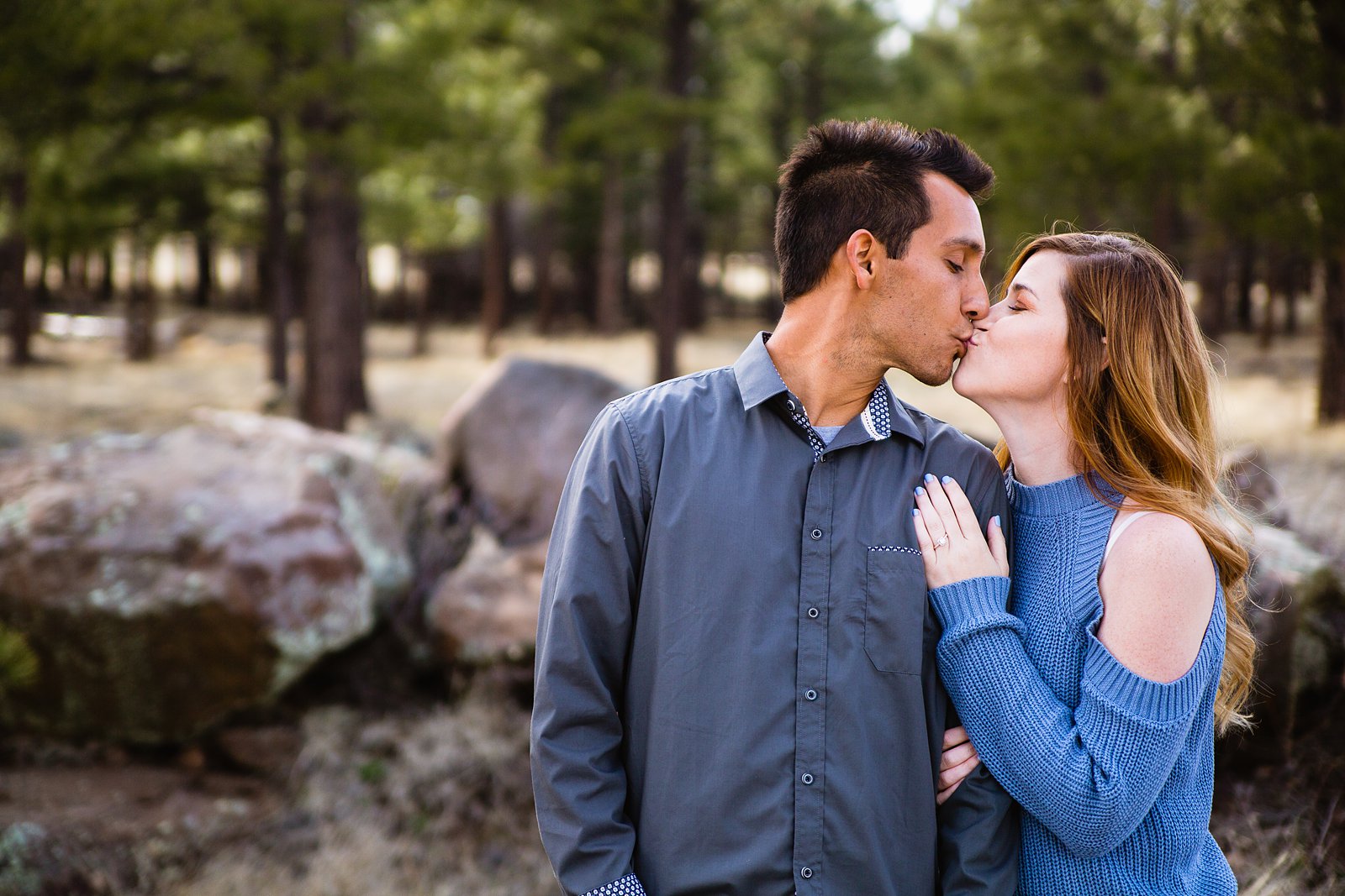 Couple share a kiss during their Flagstaff engagement session by Arizona wedding photographer PMA Photography.