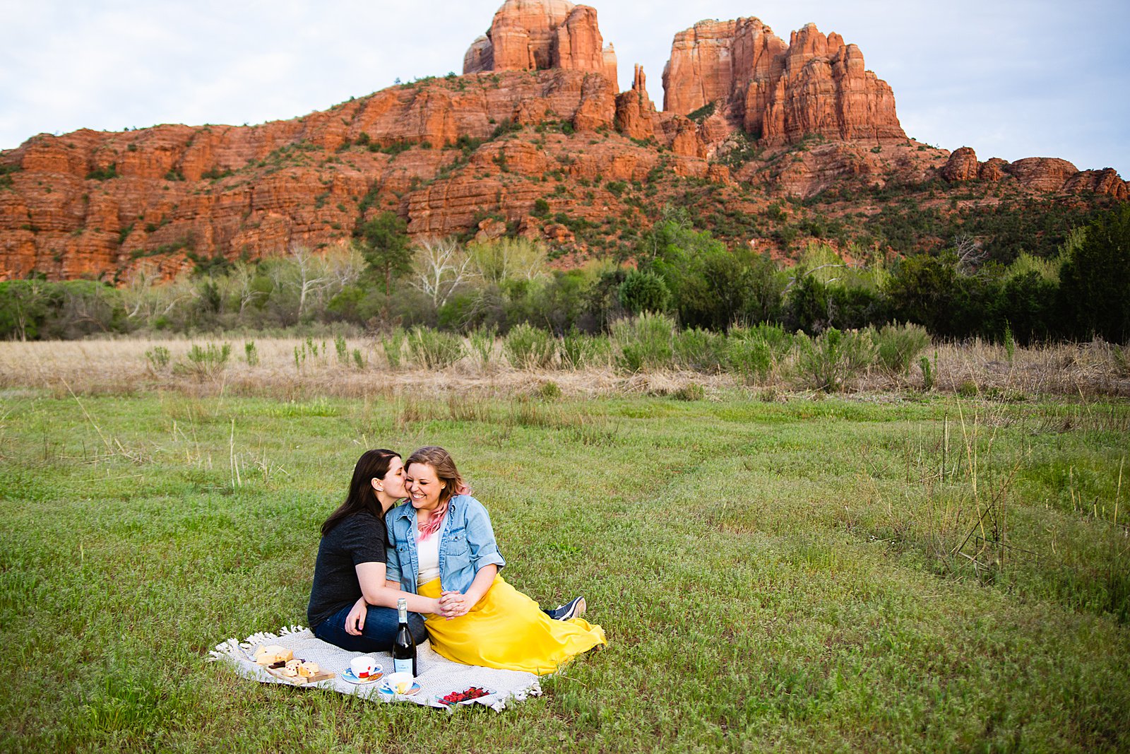 LGBTQ enjoy a picnic at Crescent Moon Ranch during their engagement session by Sedona wedding photographer PMA Photography.