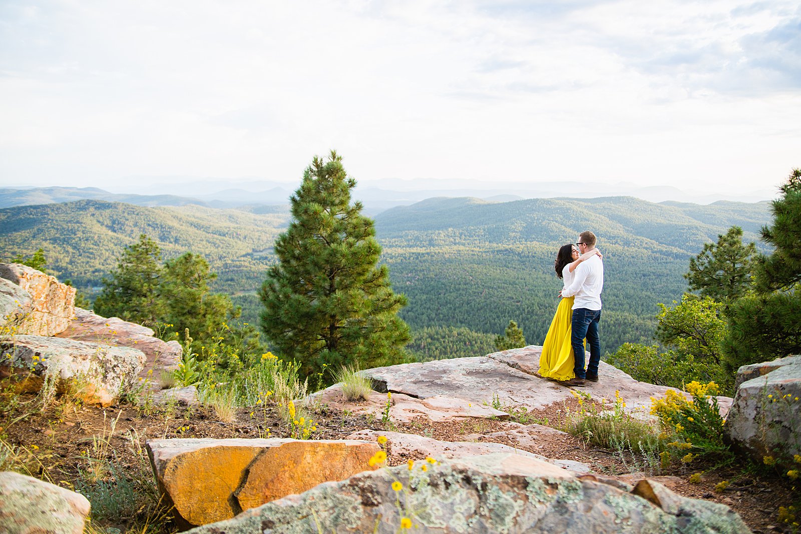 Adventurous look at each other during their Mogollon Rim engagement session by Payson wedding photographer PMA Photography.