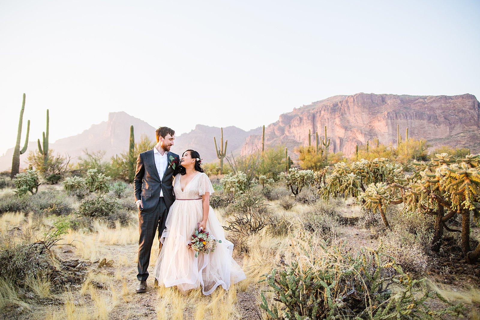 Bride and Groom pose for their Superstition Mountain Cloth and Flame wedding by Mesa wedding photographer PMA Photography.