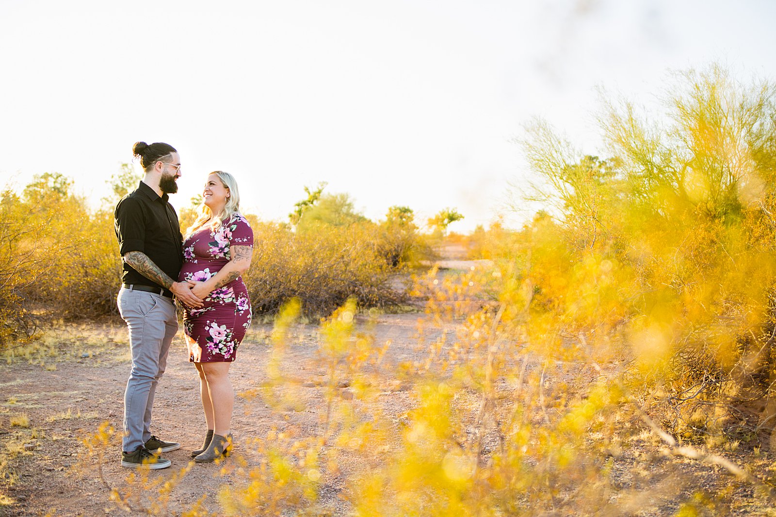 Couple pose during their Phoenix maternity session by Arizona wedding photographer PMA Photography.