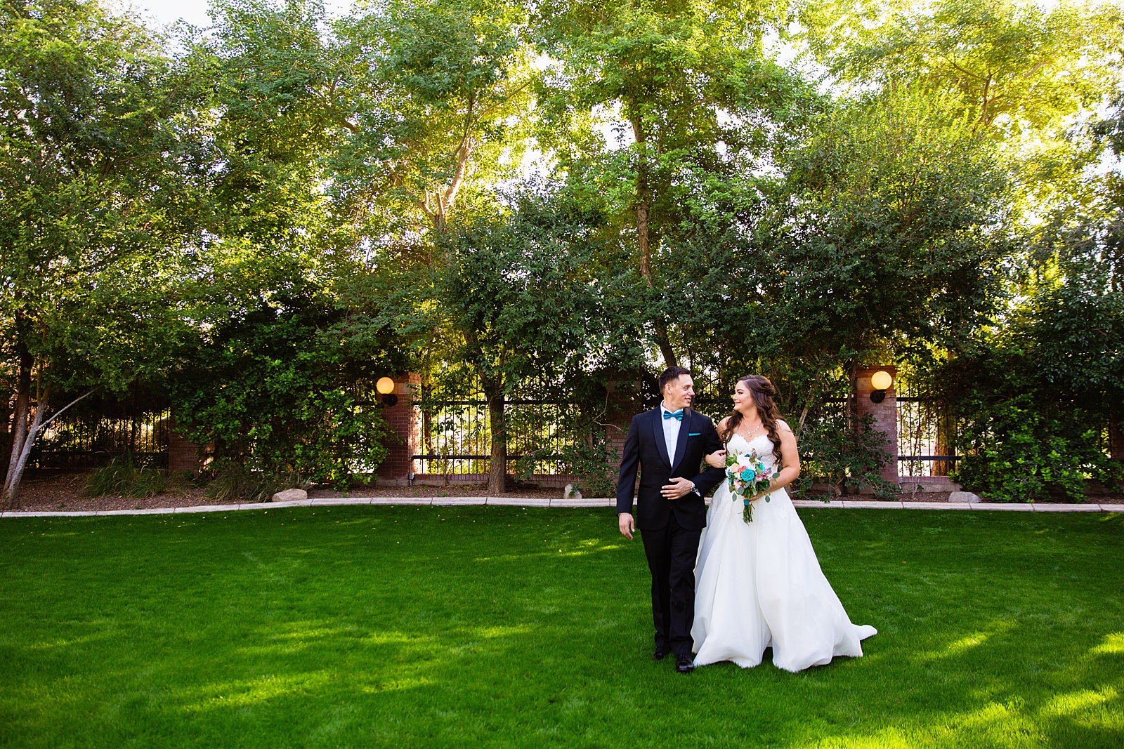 Bride and groom walking together during their Stonebridge Manor wedding by Mesa wedding photographer PMA Photography.