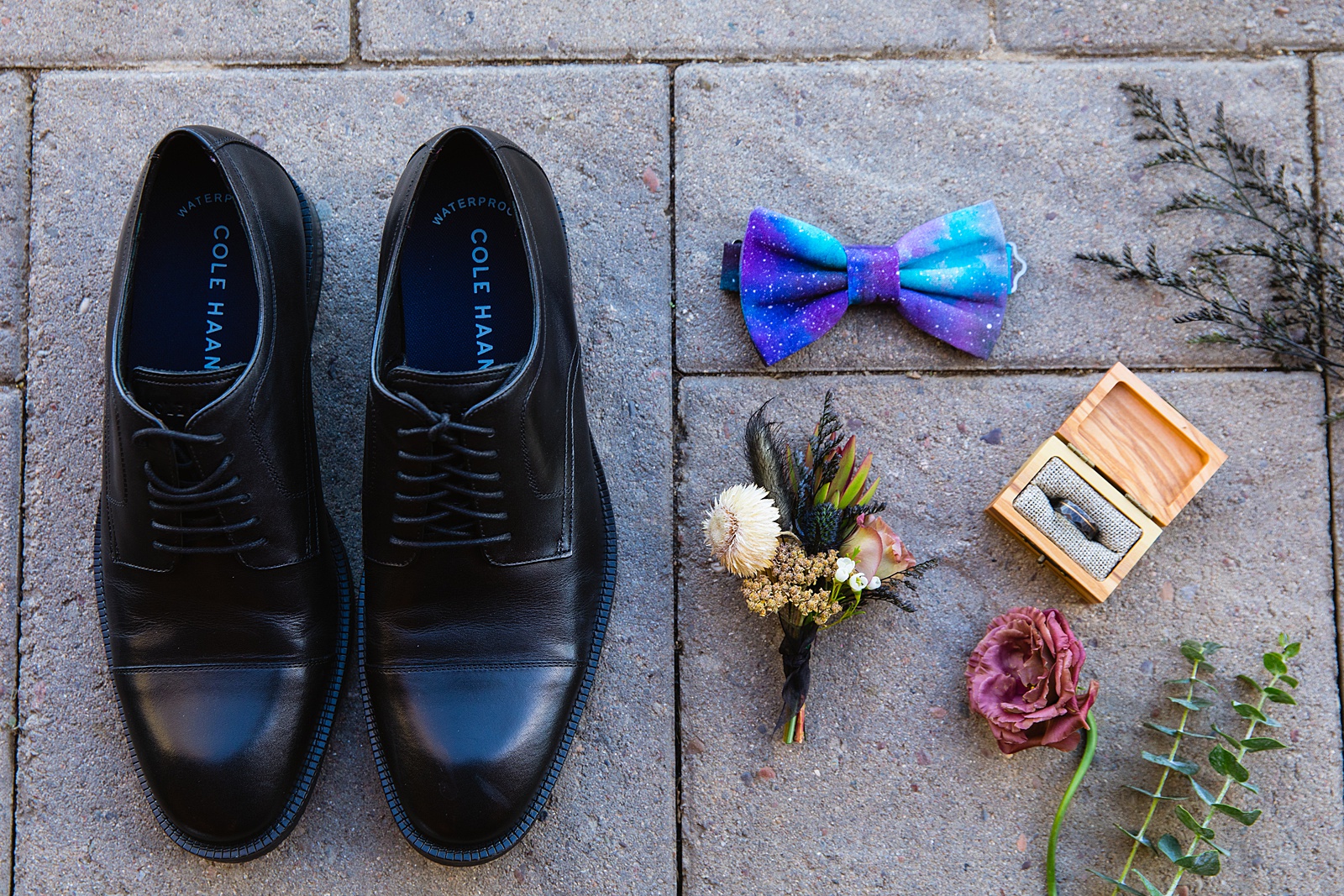 Brides's wedding day details of cosmic bow tie, black ring, and black boutonniere by PMA Photography.