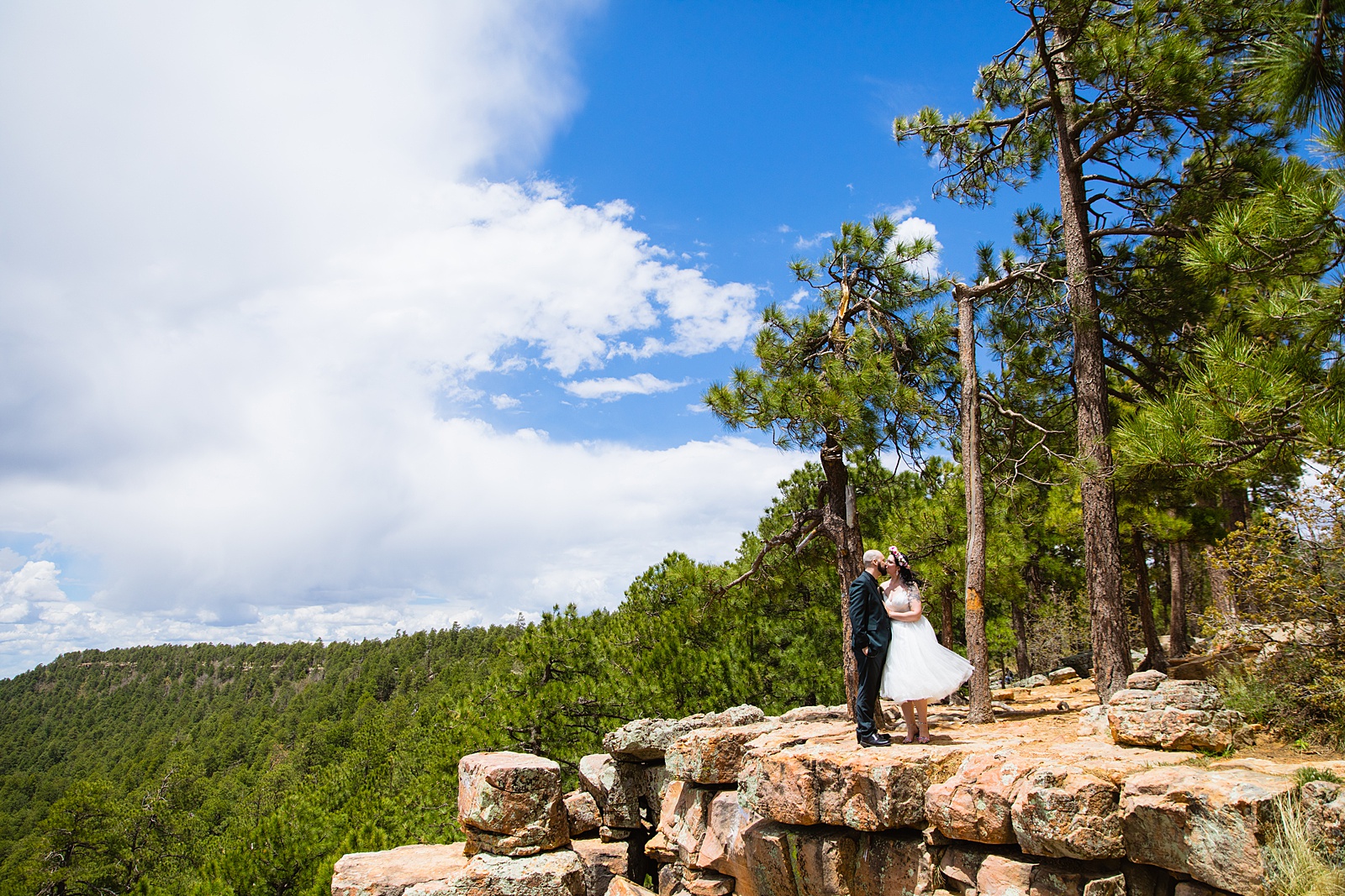 Bride and groom kiss at the edge of the rim during their elopement at the Mogollon Rim outside of Payson, Arizona by elopement photographer PMA Photography.